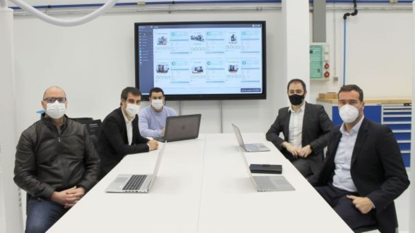 Reunion en una sala el equipo de ZITU y IMH en epoca de pandemia con mascarillas. Con una pantalla mostrando la plataforma ERIS