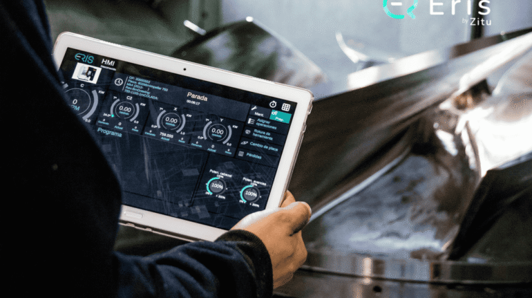 Operario delante de una máquina de mecanizado con la aplicacion de eris en la tablet